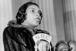 Singer Marian Anderson stands singing behind a podium at the Lincoln Memorial in Washington, D.C. 