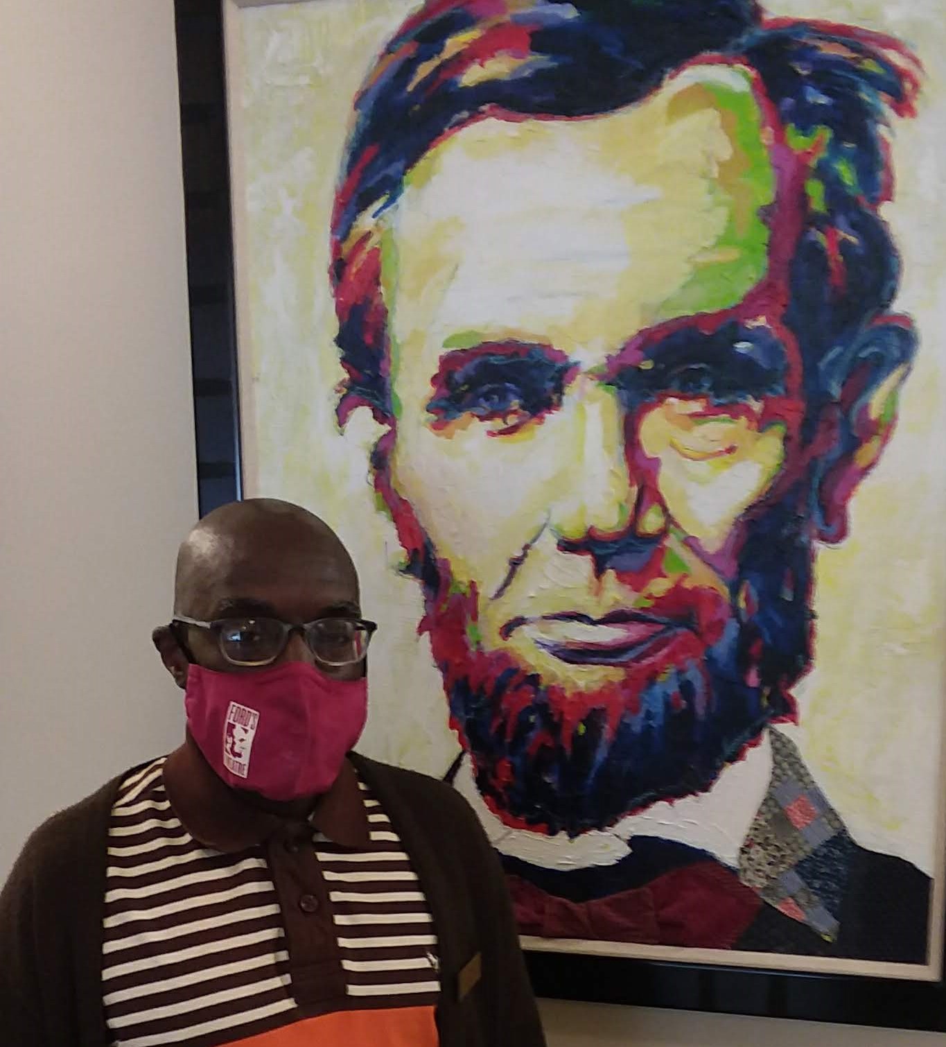 Steve stands in the Ford's Lobby by a painting of Abraham Lincoln.